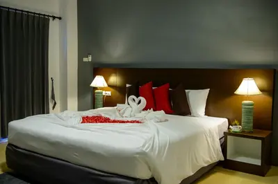 a bedroom with a large white bed with red pillows at Z-Talay House in Klong Muang Beach