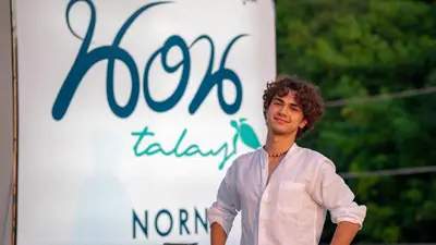 a man is standing in front of a sign at Norn Talay Surin Beach Phuket in Surin Beach