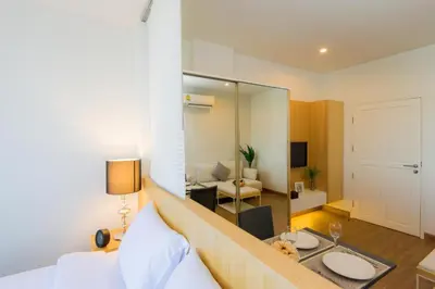 a hotel room with a bed and a living room at Hill Myna Condotel Official Account in Bang Tao Beach