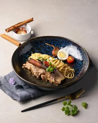 a plate of food with meat and pasta on a table at Patong Bay Hill in Patong Beach