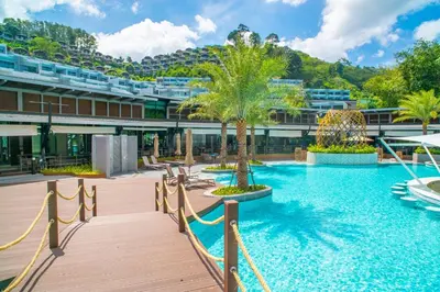 a resort with a pool with palm trees and a building at Patong Bay Hill in Patong Beach