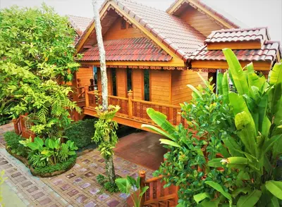 a wooden house in the middle of a garden at Ruen Tai Boutique in Nai Yang Beach