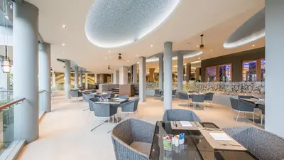 a restaurant with chairs and tables in a building at Crest Resort & Pool Villas - SHA Extra Plus in Patong Beach