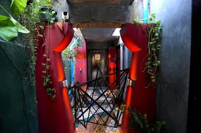 a hallway with red doors and a staircase with plants at Phuket Paradiso in Chalong