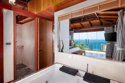 a bath tub in a bathroom with a view of the ocean at Luxury 4 pool Seaview 6 bedroom Villa on Surin Hill in Surin Beach