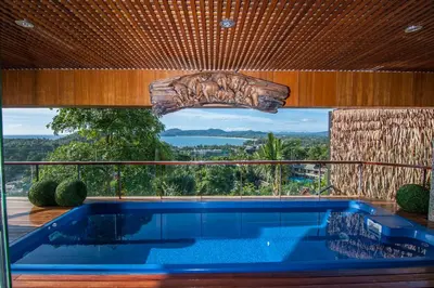 a swimming pool in a house with a large window at Luxury 4 pool Seaview 6 bedroom Villa on Surin Hill in Surin Beach