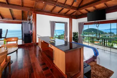 a bedroom with a desk with a view of the ocean at Luxury 4 pool Seaview 6 bedroom Villa on Surin Hill in Surin Beach