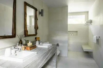 a bathroom with two sinks and a mirror at The Cove in Panwa Beach