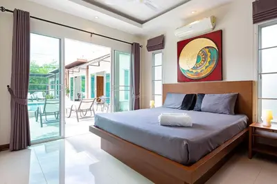 a bedroom with a bed and a balcony at Residence Harmonie in Rawai Beach