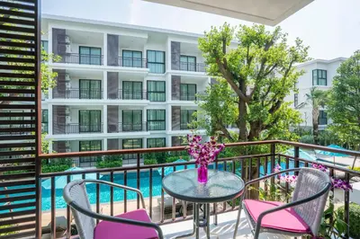 a balcony with a table and chairs and a pool at Apartments in The Title Beach Rawai in Rawai Beach