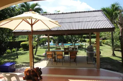 a patio with an umbrella and a table and chairs at Bann Jai Dee in Nai Yang Beach