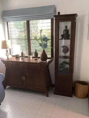 a room with a window and a wooden cabinet with vases at Bann Jai Dee in Nai Yang Beach