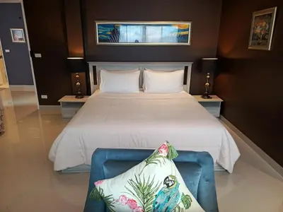 a bedroom with a large bed and a blue chair at Klong Muang Beach Apartment in Klong Muang Beach