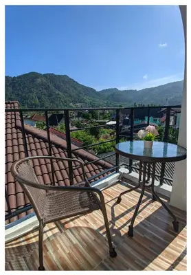 a table and chairs on a balcony with a view at 3B Apartment-SHA Extra Plus in Kamala Beach