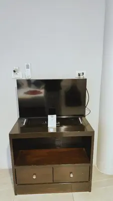 a flat screen tv sitting on top of a wooden cabinet at Naiyang Seaview Place Resort in Nai Yang Beach