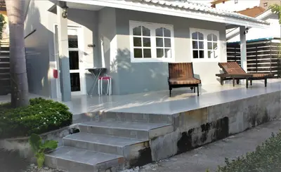 a house with two benches sitting on the front porch at 1715 House - White Rhino in Rawai Beach
