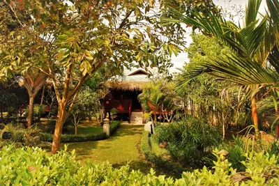a garden with trees and a house in the background at Cozy Garden Resort in Ao Nang Beach
