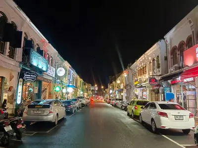 a city street at night with cars parked at Chino Town at Yaowarat Phuket - SHA Plus in Phuket Town