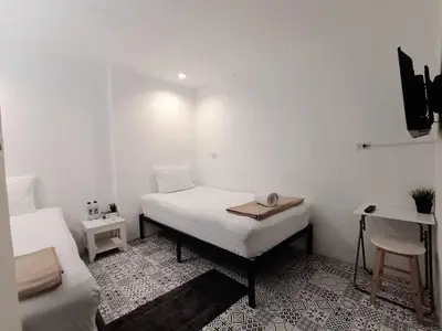 a room with two beds and a desk in it at Chino Town at Yaowarat Phuket - SHA Plus in Phuket Town
