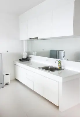 a kitchen with white cabinets and a sink at Kata Top Villas in Kata Beach
