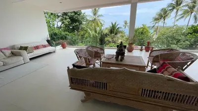 a living room with chairs and a couch and a table at Kata Top Villas in Kata Beach
