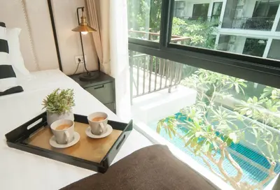 a room with two cups of coffee on a tray next to a window at The Title KR Beach Condotel Rawai Beach in Rawai Beach