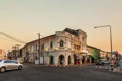 an old building on a busy city street with cars at Recenta Style Phuket Town in Phuket Town