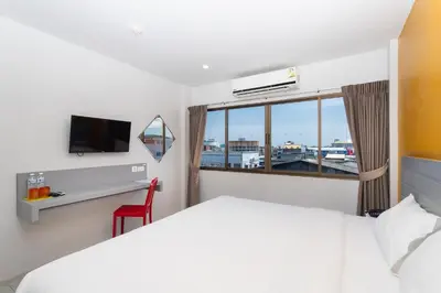 a hotel room with a bed and a window at Recenta Style Phuket Town in Phuket Town