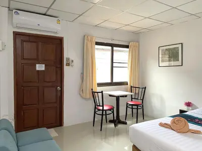 a bedroom with a bed and a table and chairs at JJ karon beach hotel in Karon Beach