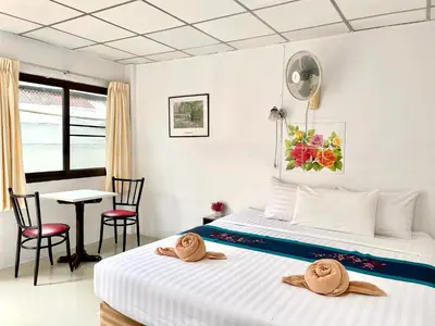 a bedroom with a bed with two chairs and a table at JJ karon beach hotel in Karon Beach