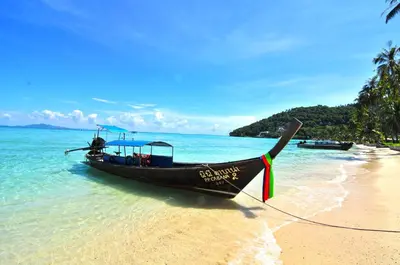 a boat on the shore of a beach at Phi Phi Little Star Resort in Phi Phi Don