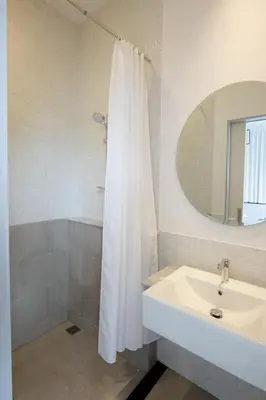 a bathroom with a white shower curtain and a sink at Surachet at 257 Boutique House in Phuket Town
