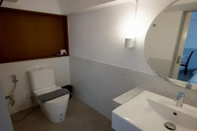 a bathroom with a toilet and a sink and a mirror at Surachet at 257 Boutique House in Phuket Town
