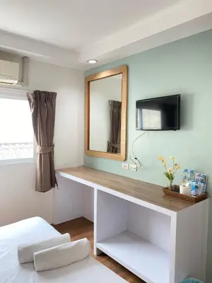 a bedroom with a desk with a mirror and a tv at Sleep at Phuket SHA Plus in Phuket Town