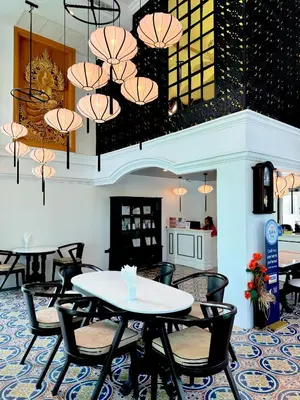 a dining room with tables and chairs and chandeliers at Grand Supicha City Hotel in Phuket Town