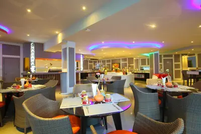 a restaurant with tables and chairs and a bar at Chabana Kamala Hotel in Kamala Beach