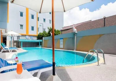 a swimming pool with an umbrella next to a building at Chabana Kamala Hotel in Kamala Beach