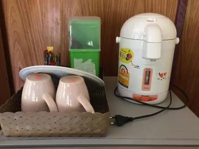a coffee maker and two tea cups on a counter at Namtok Bungalows in Ko Yao Noi