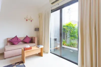a living room with a couch and a large window at Honeymooner Pool Villa@Seastone in Bang Tao Beach