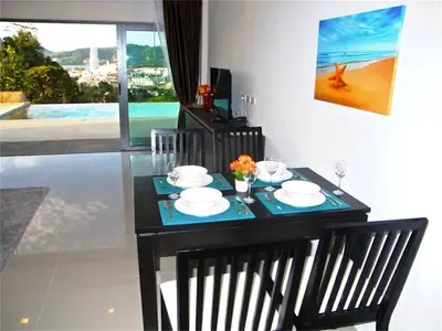a black table with plates and flowers on it at Patong Bay Hill 1 bedroom Apartment in Patong Beach