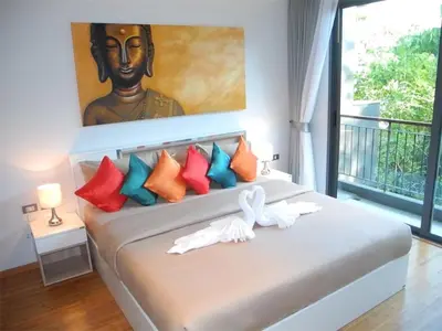 a bedroom with a bed with a large painting on the wall at Emerald Patong 1 bedroom Apartment Garden View in Patong Beach