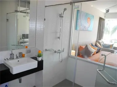 a white bathroom with a sink and a shower at Chic Karon Nice Apartment close to Karon Beach in Karon Beach