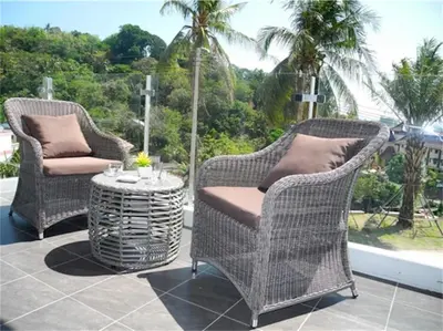 two wicker chairs and a table on a patio at Chic Karon Nice Apartment close to Karon Beach in Karon Beach