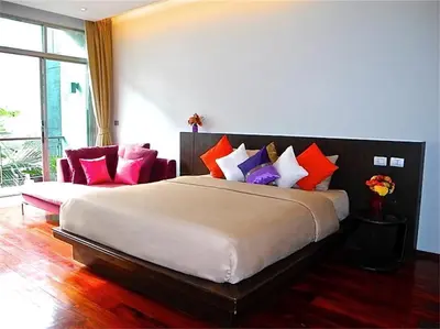 a bedroom with a large bed with colorful pillows at Eva Villa Rawai 3 bedrooms Private Pool in Rawai Beach