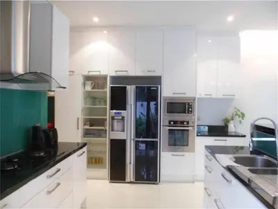 a kitchen with white cabinets and a refrigerator at Eva Villa Rawai 3 bedrooms Private Pool in Rawai Beach