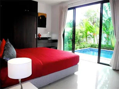 a bedroom with a red bed and a swimming pool at Intira Villa Rawai 2 bedrooms Villa in Rawai Beach