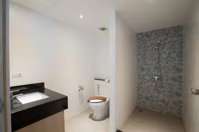 a bathroom with a toilet and a sink and a shower at The Palms, Kamala Beach - SHA Extra Plus in Kamala Beach