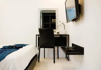 a bedroom with a desk and a bed and a television at The Yorkshire Hotel - SHA Certified in Patong Beach