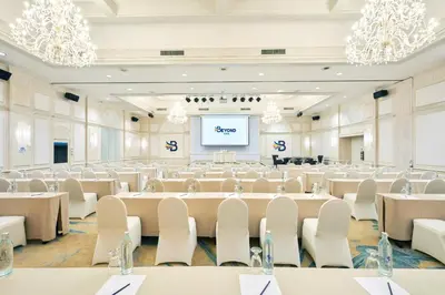 a large room with tables and chairs and a projection screen at Beyond Kata in Kata Beach