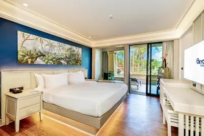 a bedroom with a bed and a desk and a piano at Beyond Kata in Kata Beach
